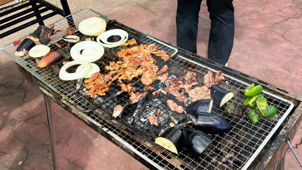 焼き台で肉と野菜を焼いている様子