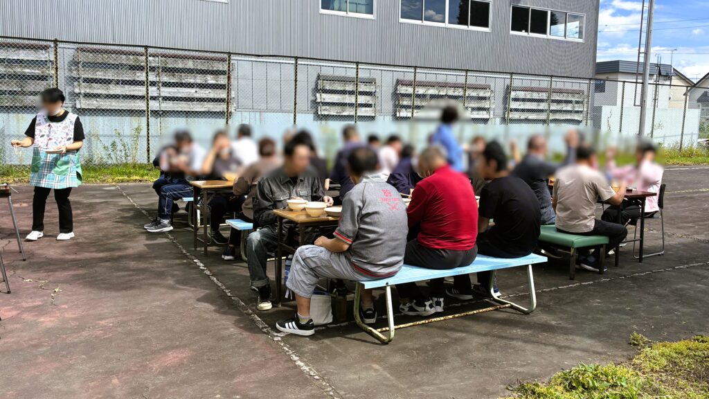 あっぷる中庭で焼肉行事に参加している利用者の皆さん